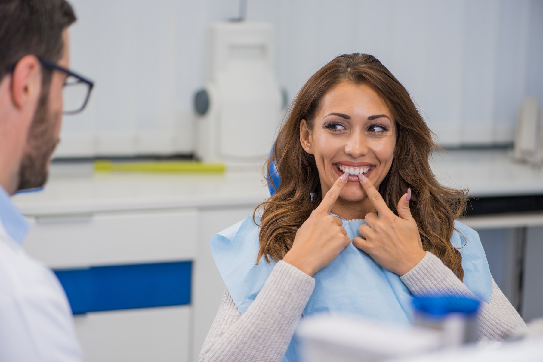 Young female patient talking with her dentist